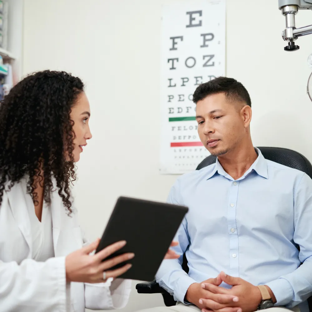 Female Optometrist explaining to a male patient. 